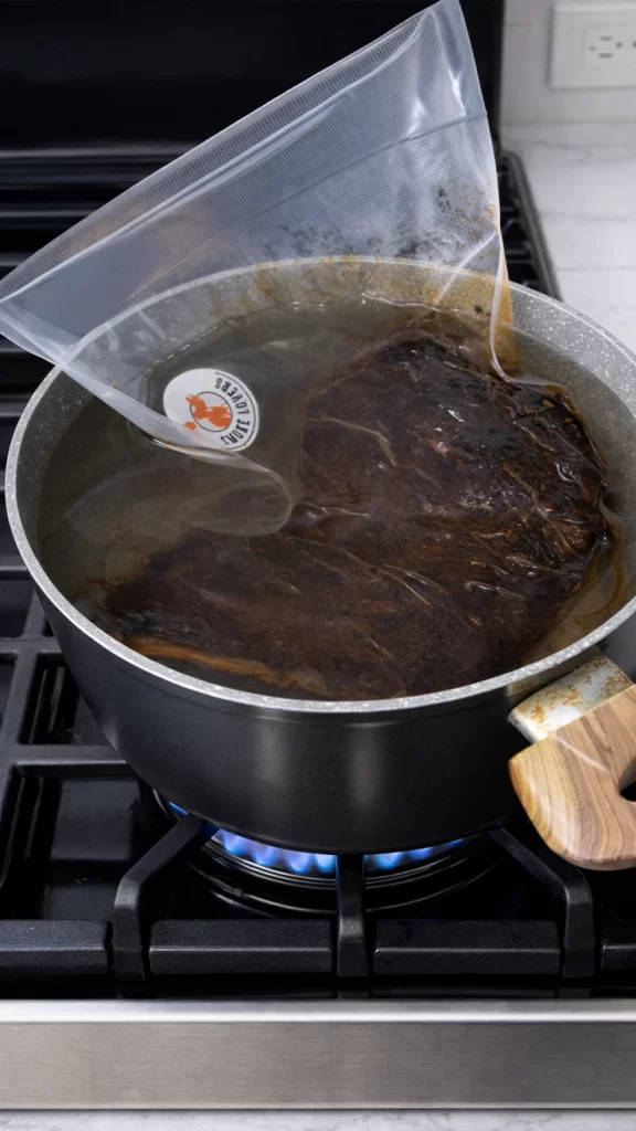 Agua caliente con la costilla empacada sumergida